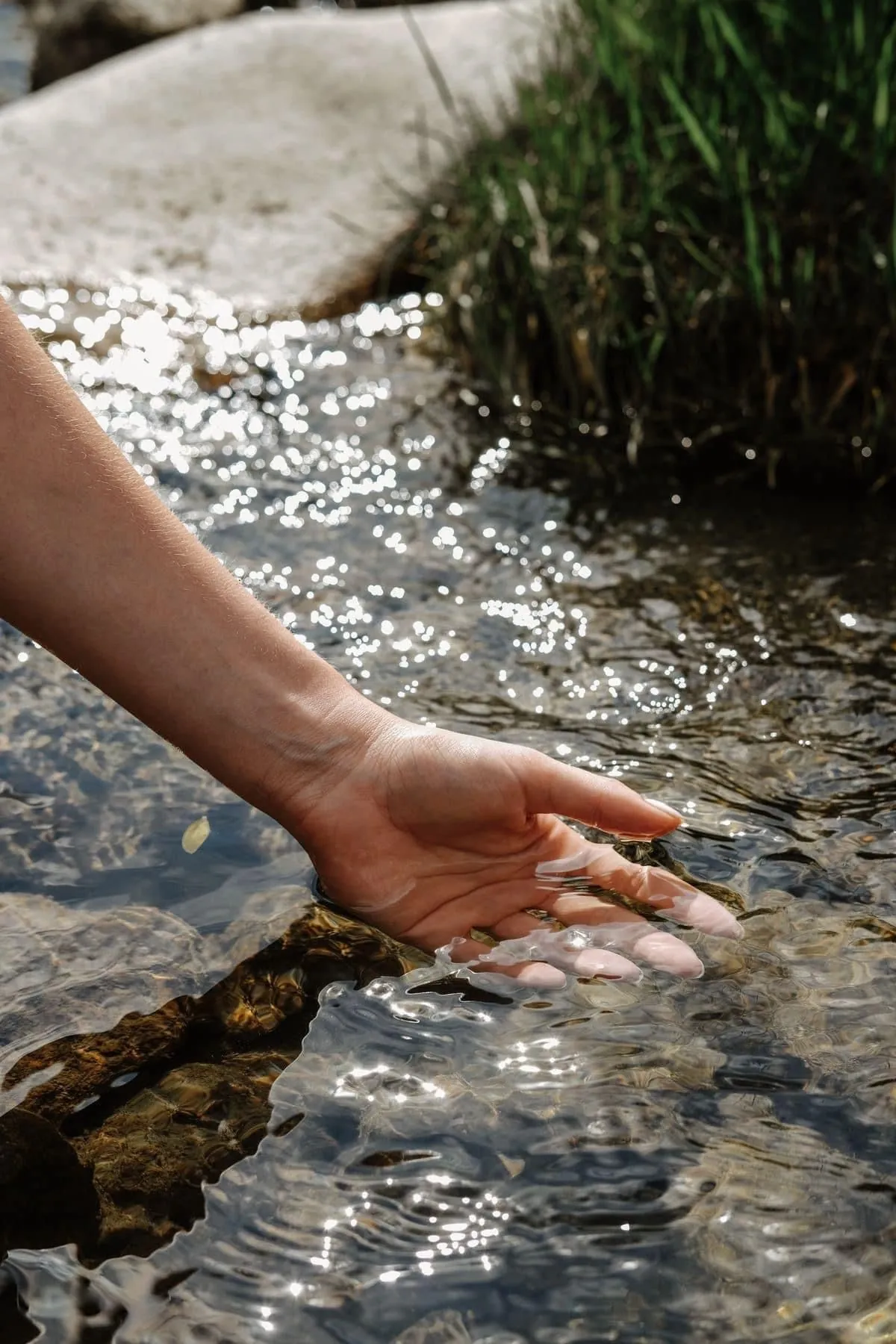A hand brushing the surface of the water